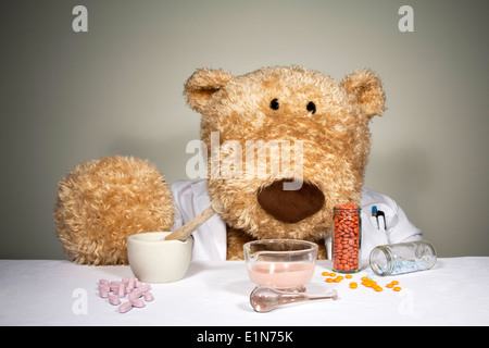De grands ours en peluche habillé en docteur sarrau blanc entouré par des mortiers et des pilons et divers comprimés Banque D'Images