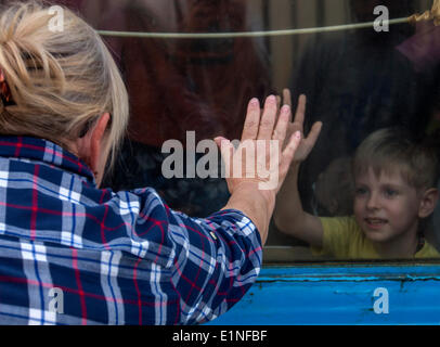 Luhansk, Ukraine. 07Th Juin, 2014. Les gens avec leurs enfants regarder à travers la fenêtre d'un train en partance pour Kiev à la gare à Luhansk, Ukraine orientale -- l'Est de l'Ukraine a été englouti par un des insurgés pro-russes au cours des deux derniers mois, avec des rebelles contre les troupes gouvernementales. Les chemins de fer ukrainiens envoyé à Luhansk trains supplémentaires. Crédit : Igor Golovnov/Alamy Live News Banque D'Images