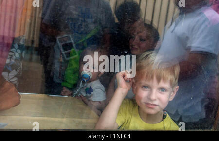 Luhansk, Ukraine. 07Th Juin, 2014. Les gens avec leurs enfants regarder à travers la fenêtre d'un train en partance pour Kiev à la gare à Luhansk, Ukraine orientale -- l'Est de l'Ukraine a été englouti par un des insurgés pro-russes au cours des deux derniers mois, avec des rebelles contre les troupes gouvernementales. Les chemins de fer ukrainiens envoyé à Luhansk trains supplémentaires. Crédit : Igor Golovnov/Alamy Live News Banque D'Images