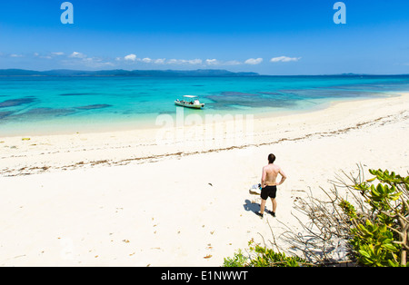 L'homme parfait admiratifs plage de sable blanc entourée d'eau tropicale d'Okinawa, Japon Banque D'Images