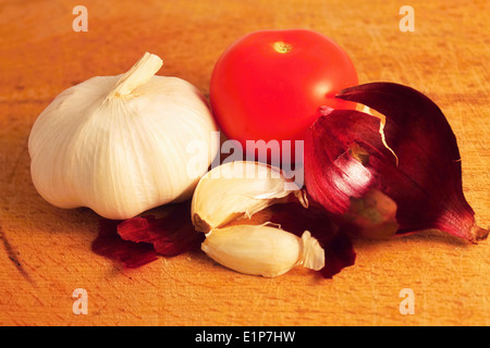 L'ail avec quelques morceaux de pelures d'oignon et de tomate et Banque D'Images