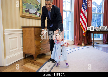 Le président américain Barack Obama tient la main et marche avec Lincoln Rose Pierce Smith, la fille de l'ancien vice-secrétaire de presse, Jamie Smith, dans le bureau ovale de la Maison Blanche le 4 avril 2014 à Washington, DC. Banque D'Images