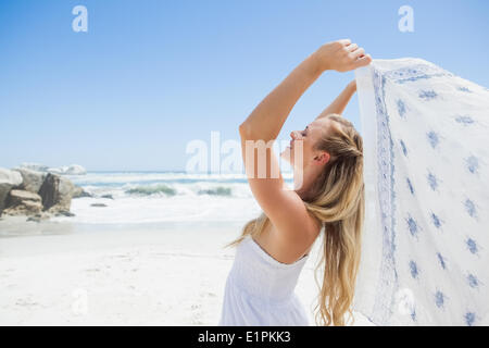 Jolie blonde posing sans souci sur la plage avec écharpe Banque D'Images