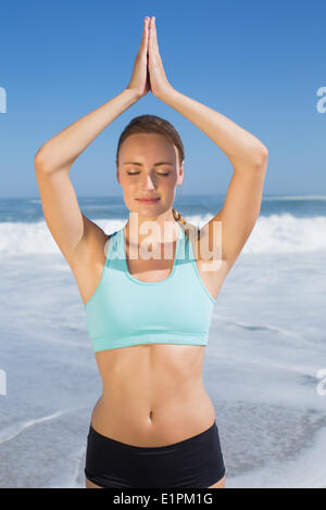Fit woman meditating on the beach Banque D'Images