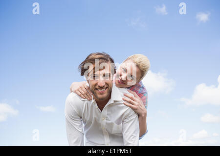 Bel homme de donner à sa petite amie à dos Banque D'Images