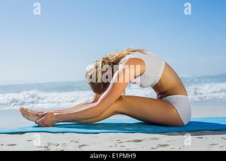 Superbe blonde monter vers l'assis à poser sur la plage Banque D'Images