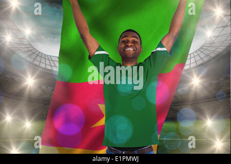 Composite image football maillot vert en tenant le drapeau du Cameroun Banque D'Images