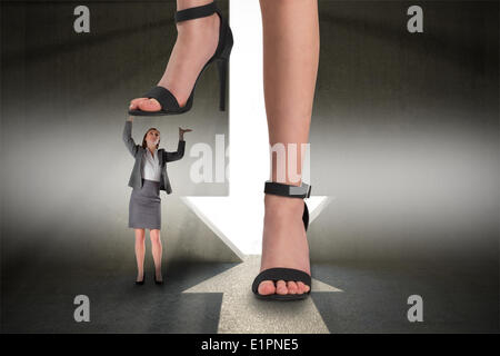 Image composite des pieds de sandales noires debout sur businesswoman Banque D'Images