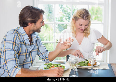 Cute smiling couple avoir un repas ensemble Banque D'Images