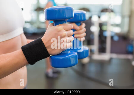 Fit woman exercising with dumbbells bleu Banque D'Images