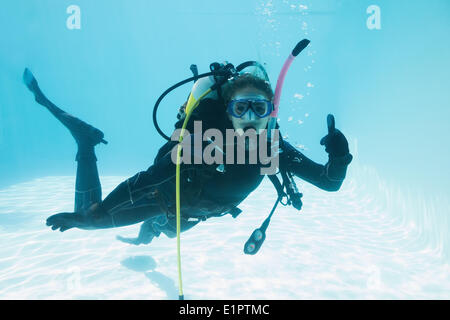 Femme sur la formation de plongée en piscine immergée showing Thumbs up Banque D'Images