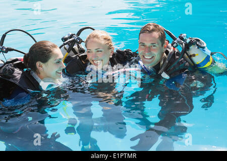 Smiling friends sur formation plongée en piscine Banque D'Images