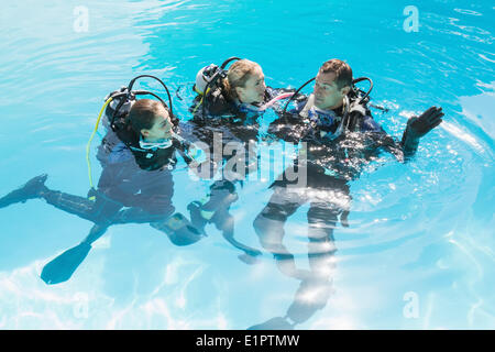 Smiling friends sur formation plongée en piscine Banque D'Images