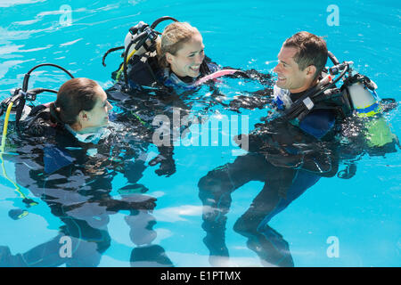 Smiling friends sur formation plongée en piscine Banque D'Images