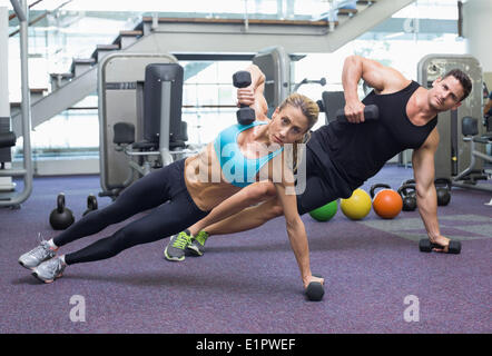 Bodybuilding man and woman holding haltères en position de planche Banque D'Images