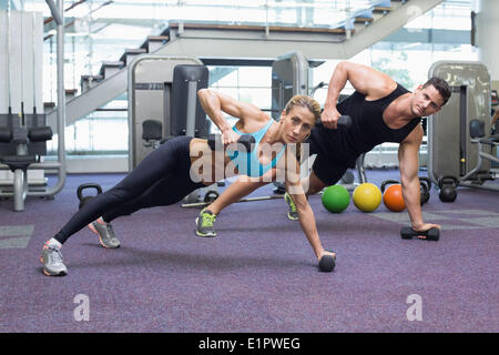 Bodybuilding man and woman holding haltères en position de planche Banque D'Images