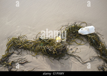 Des débris de plastique sur la plage de sable sur la côte nord de l'Irlande du Nord Banque D'Images