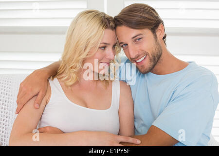 Jeune couple assis sur le canapé Banque D'Images