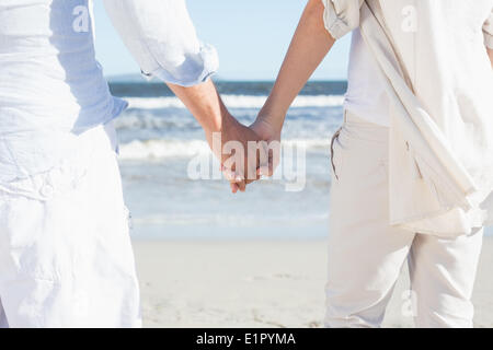 Couple sur la plage face à la mer holding hands Banque D'Images