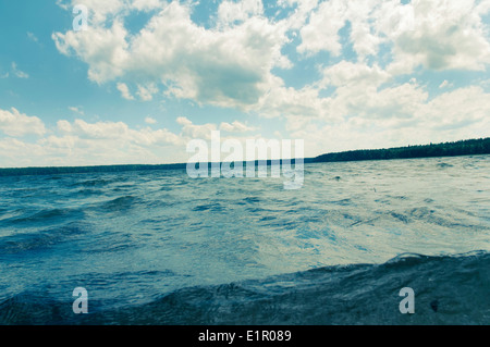 Rippled eaux froides de forest lake sous blue cloudy sky Banque D'Images