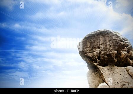 Gros rocher surplombant ciel clair Banque D'Images