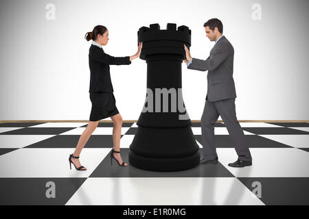 Image composite des gens d'affaires poussant chess piece Banque D'Images