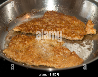 Escalopes de porc panées (schnitzel) dans une poêle à frire Banque D'Images