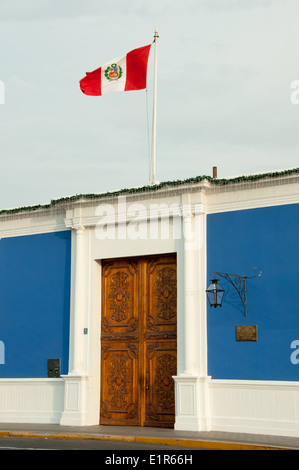 Drapeau péruvien en vol au dessus de la porte et de l'architecture coloniale de la ville de Trujillo Pérou ing Banque D'Images