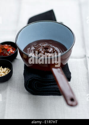 Ajouter les pignons et les fruits confits à la crème au chocolat Banque D'Images