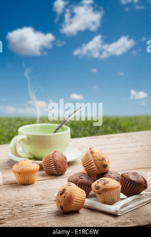 Une variété de peu avec muffin tasse de thé sur la table en bois, avec l'arrière-plan du paysage Banque D'Images