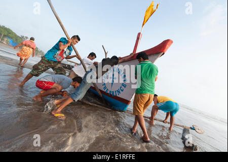 Arambol, Goa, Inde. 9 juin, 2014. Levier de pêcheurs locaux leur bateau pour un terrain plus élevé à Arambol beach comme la mousson commence à frapper le nord de la ville de Goa, en Inde. Credit : Lee Thomas/Alamy Live News Banque D'Images