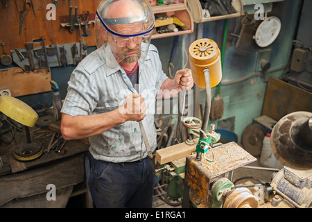 L'homme d'âge mûr en face de protection shield travaille dans l'accueil menuiserie. Banque D'Images