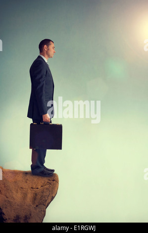 Businessman standing on the edge ou précipice ou bord d'une montagne Banque D'Images