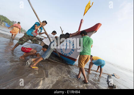 Arambol, Goa, Inde. 9 juin, 2014. Levier de pêcheurs locaux leur bateau pour un terrain plus élevé à Arambol beach comme la mousson commence à frapper le nord de la ville de Goa, en Inde. Credit : Lee Thomas/ZUMA/ZUMAPRESS.com/Alamy fil Live News Banque D'Images