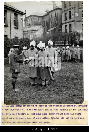 L'image représente des cigarettes présentées aux officiers blessés à l'hôpital Kitchener, Brighton, pendant la première Guerre mondiale. La scène souligne le soutien apporté aux soldats blessés, y compris les membres de divers régiments tels que le 15th Sikhs et le 39th Garhwalis. L'hôpital a joué un rôle clé dans la prestation de soins aux personnes qui ont servi pendant la guerre, symbolisant la résilience et l'engagement des soldats et du personnel médical. Banque D'Images