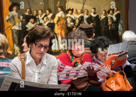 Les visiteurs de l'art galeries du Rijksmuseum à Amsterdam assis en face de grands tableaux Banque D'Images