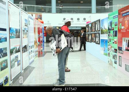 Port of Spain, Trinité-et-Tobago. 9 juin, 2014. Les visiteurs Voir les photos lors de la cérémonie d'ouverture de l'exposition photo sur le 40e anniversaire de China-Trinidad et-Tobago rapport diplomatique dans Piarco International Airport, Port of Spain, Trinité-et-Tobago, le 9 juin 2014. L'exposition affiche quelques 80 photos de 1974 à 2014 prises par les photographes de l'agence de presse Xinhua et Trinbagonian les organisations des médias comme un enregistrement complet de l'amitié et de coopération bilatérales. Credit : Gao Xing/Xinhua/Alamy Live News Banque D'Images