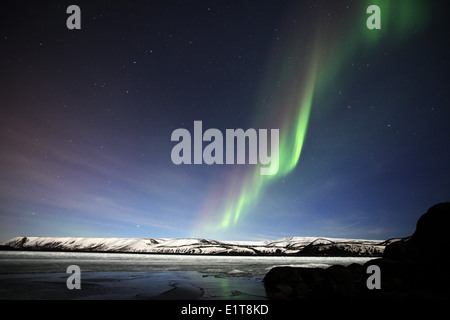 Le Nord de lumières briller au-dessus d'un lac gelé à l'extérieur de Reykjavik en Islande Banque D'Images