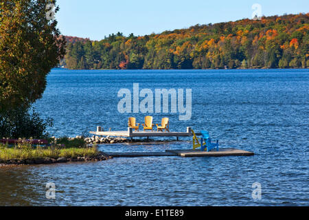 Chaises Adirondack sur les quais au lac Meech dans le parc de la Gatineau, Gatineau, Québec, Canada. Banque D'Images
