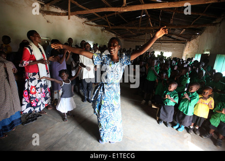 Les villageois et les enfants de l'école danse à l'école financée par une ONG dans le district de Nyagatare Rwanda Banque D'Images