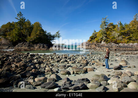 Une femme jouit de la vue sur la plage MacKenzie près de Tofino, Colombie-Britannique Canada sur l'île de Vancouver à l'UNESCO de Clayoquot Sound Banque D'Images