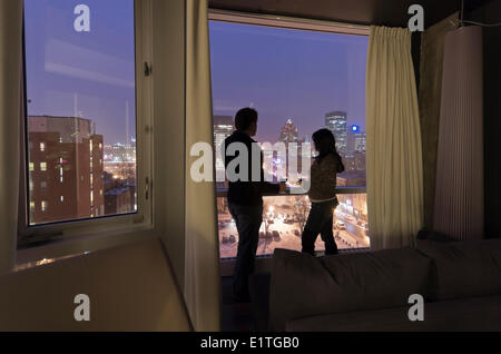 Couple avec un verre de vin dans un hôtel de Montréal vue sur la vieille ville de Montréal la nuit, Canada Banque D'Images