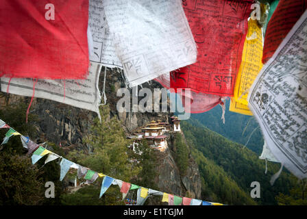 Taktsang (NID) pics tigres monastère derrière certains drapeaux de prière au-dessus de Paro, Bhoutan Banque D'Images