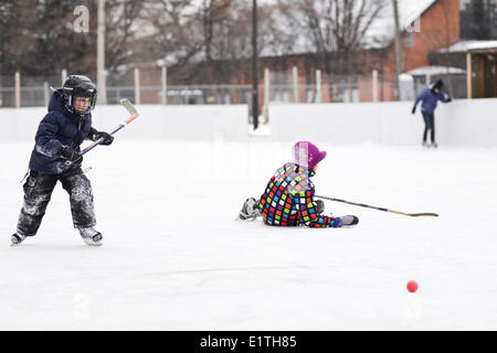 Les garçons jouer au hockey sur glace, sur une patinoire extérieure, Winnipeg, Manitoba, Canada Banque D'Images