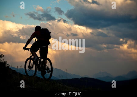 Un vélo de montagne équitation à ridgetop au coucher du soleil. Canmore, Alberta, Canada Banque D'Images