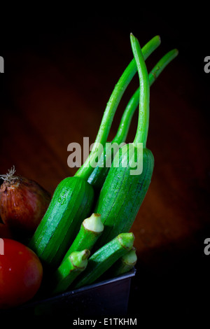 Légumes frais [trois] luffa okra quatre tomates oignon ensemble dans des conteneurs de matières premières racines tige vert jaune rouge couleur couleur Banque D'Images