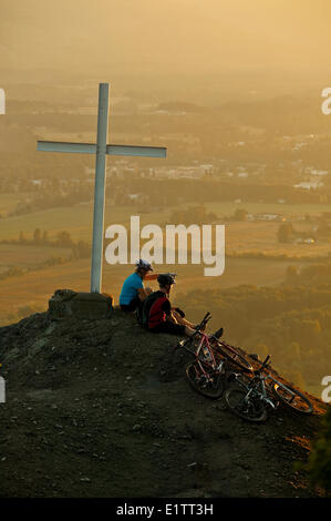 Les amis reste le long d'un sentier de vélo de montagne sur Mt. Tzoulalem avec vue sur Duncan, Centre de l'île de Vancouver, Colombie-Britannique, Canada Banque D'Images