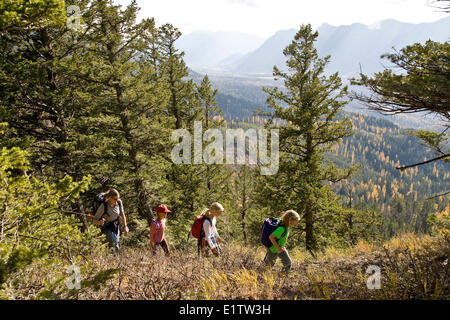 Jeune famille randonnées sur sentier de montagne Château en automne, Fernie, BC, Canada. Banque D'Images