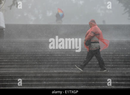 Beijing, Chine. 10 Juin, 2014. Une randonnée pédestre dans la pluie à l'extérieur du National Centre for the Performing Arts (NCPA) à Beijing, capitale de Chine, le 10 juin 2014. Une pluie torrentielle a frappé la capitale mardi après-midi. Credit : Luo Xiaoguang/Xinhua/Alamy Live News Banque D'Images