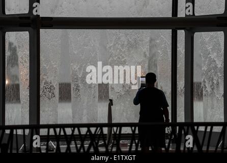 Beijing, Chine. 10 Juin, 2014. Un touriste prend des photos d'une pluie diluvienne au National Center for the Performing Arts (NCPA) à Beijing, capitale de Chine, le 10 juin 2014. Une pluie torrentielle a frappé la capitale mardi après-midi. Credit : Luo Xiaoguang/Xinhua/Alamy Live News Banque D'Images